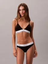 Bombacha clásica tipo bikini de Calvin Klein, color negro, confeccionada en mezcla de algodón, modal y elastano. Presenta una pretina elástica distintiva con el logo de la marca en contraste y ofrece cobertura total en la espalda.