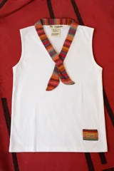 Musculosa blanca de algodón, sin mangas, con cuello en V decorado con una faja de tela tejida multicolor de estilo artesanal y un parche a juego en el dobladillo inferior.
