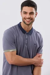 Remera polo de manga corta en color índigo con cuello y botones en contraste. Presenta detalles de color en los puños, aportando un toque sutil y moderno.