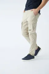 Pantalón cargo de corte slim, color negro, con bolsillos laterales con solapa y botones metálicos. Cuenta con cierre frontal, botón en la cintura y pasacintos.
