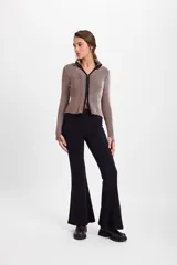 Pantalón de felpa gris con corte flare y terminación acampanada. Presenta una pretina elástica y detalle de costura vertical tipo alforza en el centro delantero.