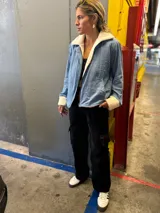 Campera de jean celeste con interior y cuello de corderito color crema, cierre frontal con cremallera y bolsillos laterales.