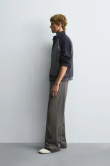 Cazadora relaxed fit en color block, con cuerpo gris oscuro y mangas azul marino. Presenta cuello subido, manga larga, bolsillos frontales de vivo, vivos combinados a contraste en blanco, acabados con rib elástico y cierre frontal con cremallera.