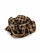 Gomita para el pelo tipo scrunchie con diseño a cuadros en tonos beige y negro, con borde de terminación en hilo al tono.
