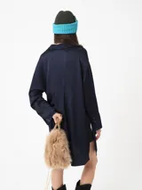 Camisa amplia color blanco, de textura arrugada, con laterales abiertos y detalle de tabla en la espalda.