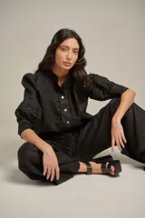 Pantalón capri color ladrillo, de tiro alto y pierna ancha, confeccionado en lino.