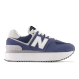Championes urbanos New Balance modelo 574, color azul con detalles en gris y blanco, confeccionados en gamuza y malla, con logo "N" característico en los laterales y entresuela con plataforma.