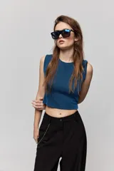 Top de textura acanalada y calce al cuerpo, sin mangas, con cuello redondo y diseño de espalda abierta con lazo para anudar.