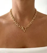 Collar de eslabones texturados en acero dorado, con cierre marinero frontal en forma de barra y argolla.