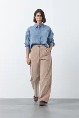 Pantalón de pana de corte flare, con tiro alto, bolsillos frontales tipo parche y cierre con botón y cremallera.