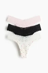 Pack de tres bombachas tipo colaless de tiro bajo con cintura en V y ribete ancho de encaje. El set incluye una prenda rosa, una negra y una blanca con estampado de corazones rojos.