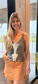 Musculosa de tejido de punto gris, con tirantes finos, escote en V y un llamativo aplique frontal de cuero plateado en forma de flecha.