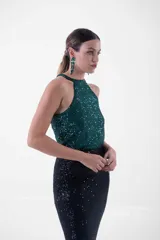 Vestido largo de fiesta con lentejuelas, compuesto por un top verde esmeralda con cuello halter y una falda negra ajustada con abertura lateral.