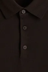 Remera polo de manga larga en punto de lana merino suave, color marrón oscuro, con cuello y tapeta de botones. Presenta remate acanalado en puños y bajo.