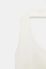 Body de cuello halter confeccionado en tejido rib, con diseño de espalda descubierta y cierre inferior.