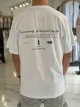 Remera oversize blanca de manga corta con estampado tipográfico y gráfico en la espalda.