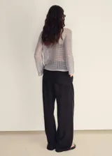 Jersey de punto calado color gris, con diseño de red transparente, cuello redondo y mangas largas acampanadas.