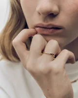 Anillo de oro con diseño ondulado y pequeños cristales incrustados.