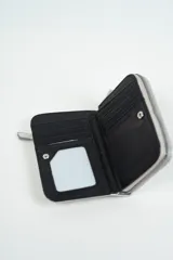 Billetera tipo sobre, color plateado con acabado metalizado y textura craquelada. Presenta un diseño con dos ojales frontales y un bolsillo exterior con cierre metálico.