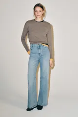 Jeans wide leg de tiro alto y diseño de cinco bolsillos, con efecto lavado, trabillas en la cintura y cierre frontal con cremallera y botón metálico.