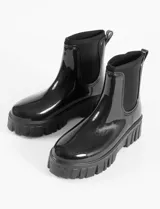 Botas de lluvia tipo chelsea con acabado brillante, suela track robusta y paneles laterales elásticos a tono.