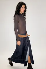 Falda midi de denim azul oscuro con costuras a la vista en contraste. Presenta un diseño de corte recto con paneles verticales y un cinturón de gamuza en tono tostado con hebilla metálica.