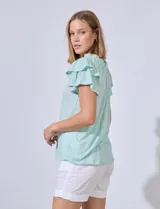Blusa color verde agua con cuello redondo fruncido y lazo. Tiene mangas cortas con volados.
