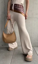 Pantalón acampanado color beige de tejido de punto acanalado.