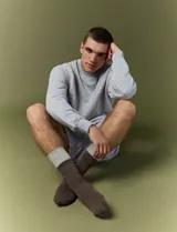 Sweater básico de cuello redondo y manga larga, confeccionado en tejido circular con puños y cuello en tejido canalé.
