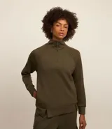 Buzo deportivo verde oliva de microfibra pesada, con cuello alto con cremallera, recorte en los hombros y dos aberturas en la parte de abajo.