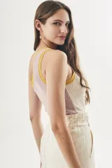 Top tejido color crema con rayas verticales y ribete amarillo en el escote asimétrico.
