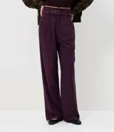 Pantalón de sastrería corte recto, color negro, con pliegues delanteros, cierre de botón y cremallera, y cinturón integrado con hebilla metálica.