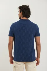 Remera polo de manga corta en color azul oscuro con estampado de pequeños puntos celestes. Presenta cuello clásico, cierre frontal con dos botones y terminaciones acanaladas en las mangas.
