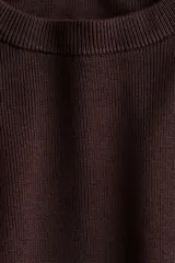 Remera de punto color marrón oscuro, de textura tupida, con cuello redondo acanalado, mangas cortas con hombros caídos y bajo recto.