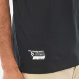 Remera negra de cuello redondo y manga corta, con estampa frontal con texto y diseño gráfico en blanco y negro.