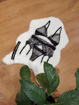 Conjunto de lencería compuesto por corpiño triangular, bombacha tipo colaless y portaligas, confeccionado en encaje negro con estampado animal print.