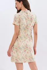Vestido corto de lino estampado con diseño floral en tonos pasteles, de manga corta, con cuello camisero y cierre frontal de botones.