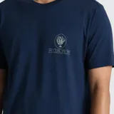 Remera de manga corta color azul marino, con cuello redondo y estampa pequeña en el pecho que incluye un diseño de algas y el logo de la marca Roark.
