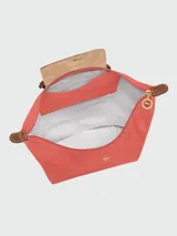 Mochila Longchamp modelo Le Pliage Original en tamaño M, color verde oscuro. Presenta solapa y asas de cuero marrón con cierre de botón a presión, correas ajustables de tela y cierre superior con cremallera.