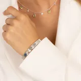 Brazalete abierto de plata 925 con tres piedras peridoto ovaladas, ajustable a la muñeca.