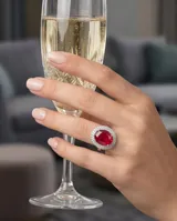 Anillo de plata 925 con piedra central ovalada de raíz de rubí en color rojo intenso, rodeada por un engaste de circonias brillantes.
