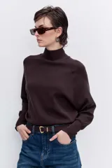 Sweater de punto negro con cuello alto y mangas largas con corte raglán.