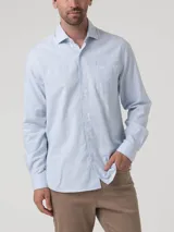 Camisa de manga larga RKF modelo Flasquare, confeccionada en franela de algodón con textura de microcuadros en tono celeste. Presenta cuello clásico, cierre frontal con botones y un bolsillo en el pecho con el logo de la marca bordado.