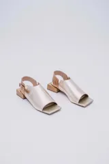 Sandalias de cuero color marrón con puntera abierta, talón descubierto y tira trasera con hebilla. Taco bajo de madera.