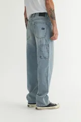 Pantalón de jean celeste de corte recto y holgado, con bolsillos laterales y traseros, y detalle de bolsillo tipo carpintero en la pierna.