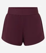 Short deportivo modelo runner color bordó, con cintura elástica ancha y bajo redondeado. Presenta un diseño holgado ideal para actividades físicas.