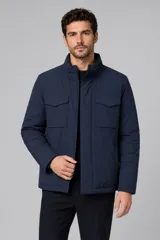 Campera de abrigo color azul marino, con cuello alto, cierre frontal oculto y dos bolsillos frontales con solapa.