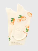 Calcetines de largo medio en color crema con estampado de limones y hojas verdes. Presentan un puño superior con borde ondulado y diseño suave.