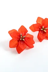 Aros con diseño de flor en color naranja y detalle dorado en el centro.