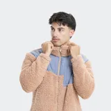 Campera de polar tipo sherpa en color beige, con paneles superiores en color azul grisáceo. Presenta cuello alto, cierre frontal completo y un bolsillo en el pecho con cierre y logo de la marca.